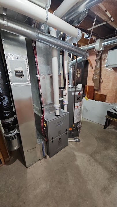 New hot water tank installed beside a furnace