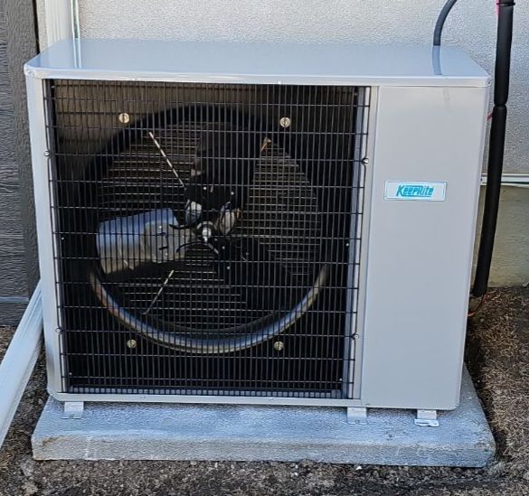 KeepRite AC condenser, freshly installed beside a home
