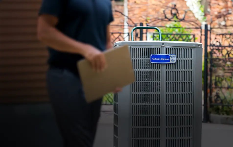 Technician with an inspection checklist beside an outdoor AC unit